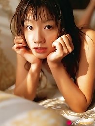 Beautiful gravure idol chick laying around in bed in white shorts