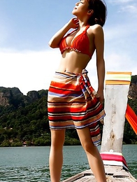 Japanese Yumiko Shaku  in orange bath suit takes a walk on the beach