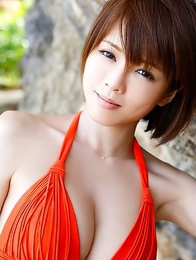 Japanese Yumiko Shaku  in orange bath suit takes a walk on the beach